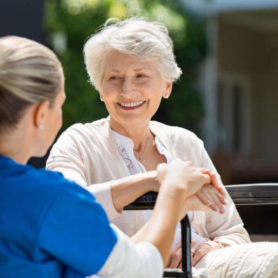 Happy conversation between aged lady and caregiver.