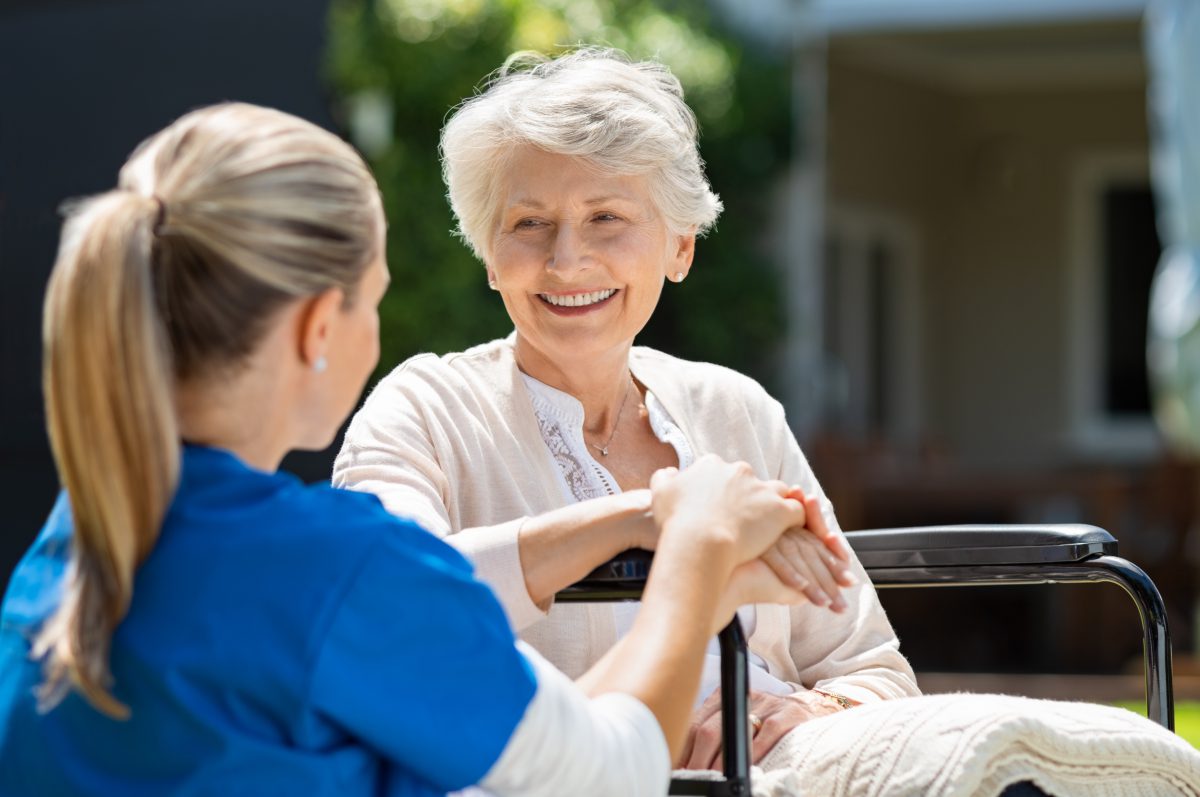 Happy conversation between aged lady and caregiver.