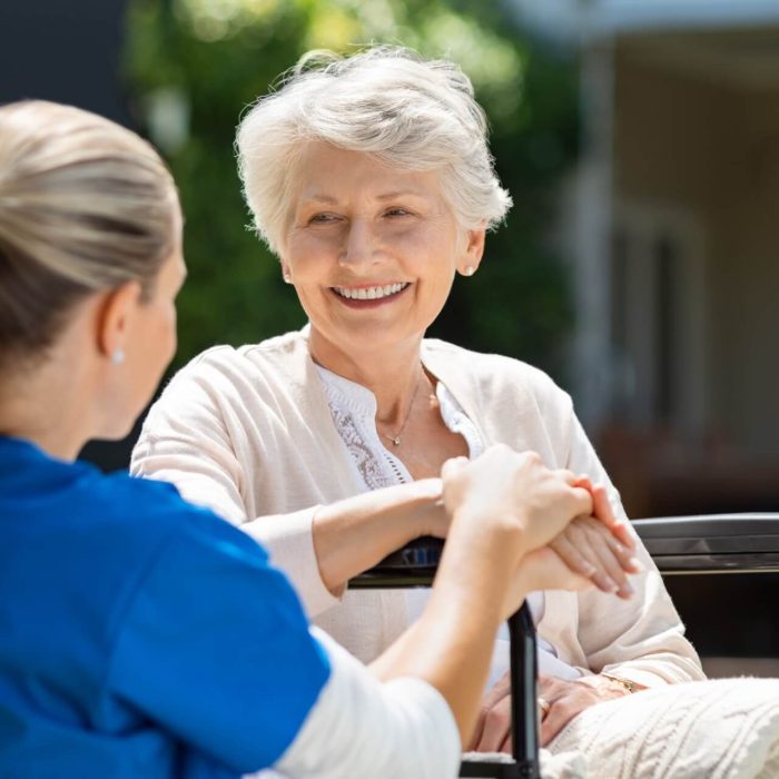 An elderly woman pleasantly talking with her caregiver.